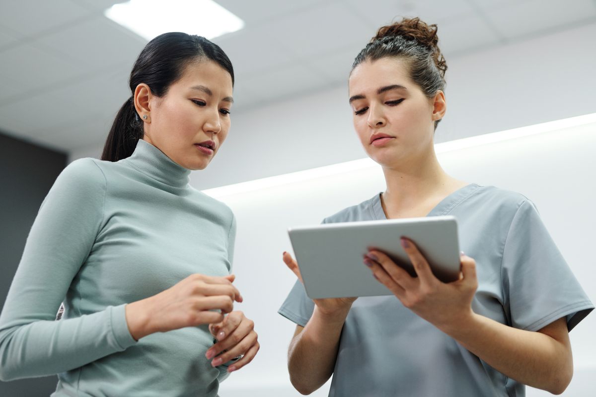 Two healthcare team members reviewing patient information together on a tablet
